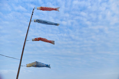 Low angle view of flags hanging against sky