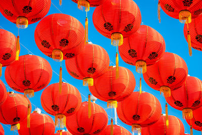 Low angle view of lantern hanging in row against sky