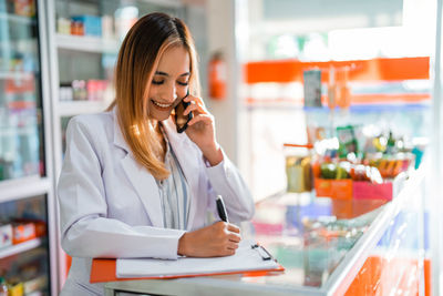 Businesswoman talking on mobile phone in cafe