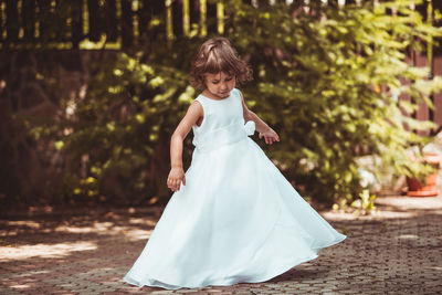 Full length of girl standing on land against trees