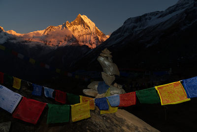 Multi colored umbrellas on snowcapped mountains against sky