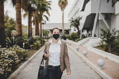 Man wearing sunglasses standing against built structure