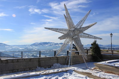 Traditional windmill against sky during winter