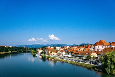 River amidst buildings against blue sky