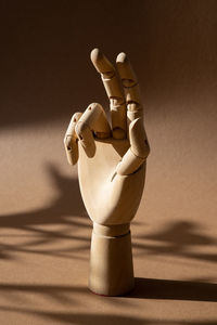 Close-up of figurine on table against wall