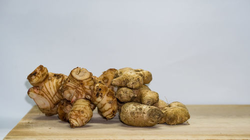 Close-up of bread on table against white background