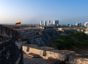 Buildings in city against clear sky