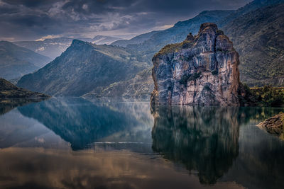 Scenic view of lake by mountains against sky