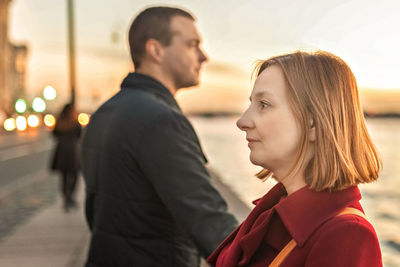 Young couple man and woman on the embankment of the river in the city. 