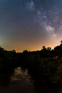 Scenic view of silhouette trees against sky at night