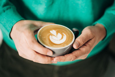 Close-up of hand holding coffee cup