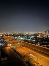 High angle view of illuminated city against sky at night