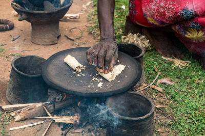 High angle view of woman preparing food on firewood