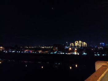 Illuminated cityscape against sky at night