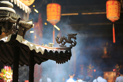 Close-up of statue against illuminated temple