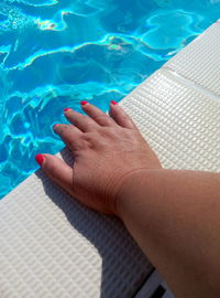 Low section of woman legs in swimming pool