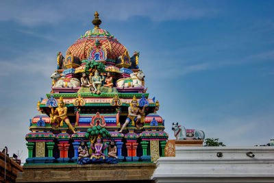 Low angle view of statue against temple building against sky