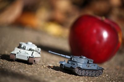 Close-up of armored tanks against apple on footpath