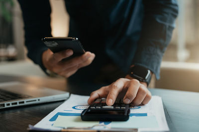 Midsection of man using mobile phone