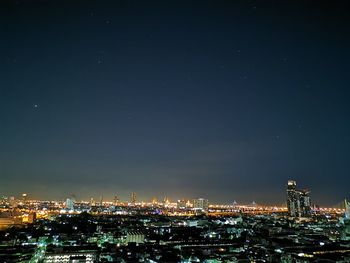 High angle view of illuminated buildings against sky at night