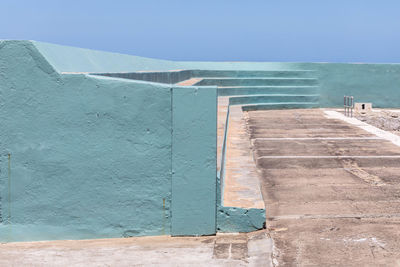 View of wall by swimming pool against clear sky