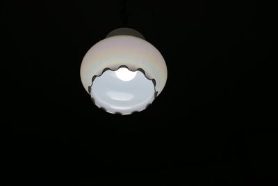 Low angle view of illuminated light bulb in the dark