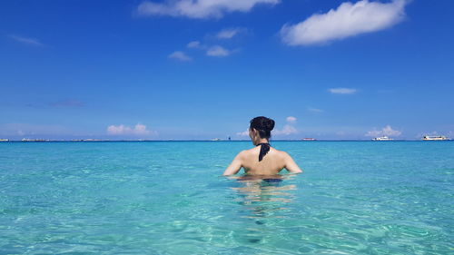 Full length of shirtless man in swimming pool against sky