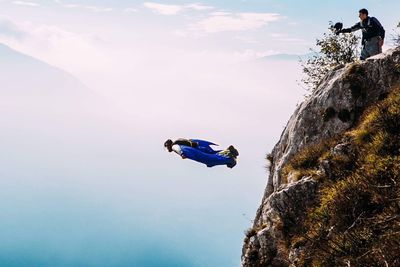 Woman on mountain against blue sky