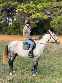 Full length of man riding horse on plants