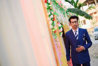 Portrait of groom in suit during wedding ceremony