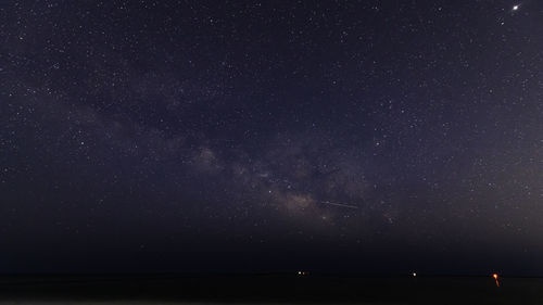 Scenic view of sea against star field at night