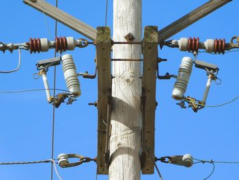 Low angle view of cables against clear blue sky