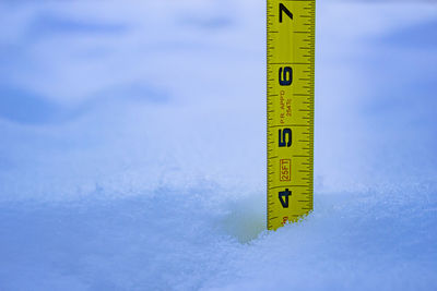 Close-up of snow covered information sign