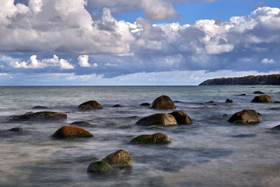 Rocks on sea shore against sky