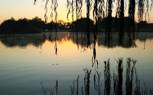 Scenic view of calm lake at sunset