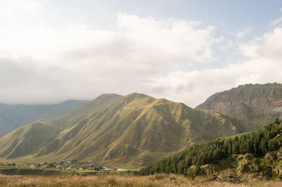 High mountains and nature on the georgian military road. a small settlement near the mountain