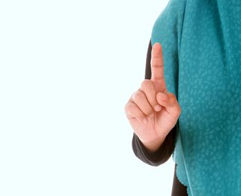 Close-up of hand holding eyeglasses against white background