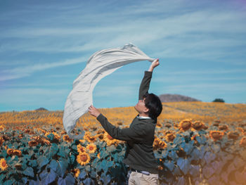 Woman standing on field against sky