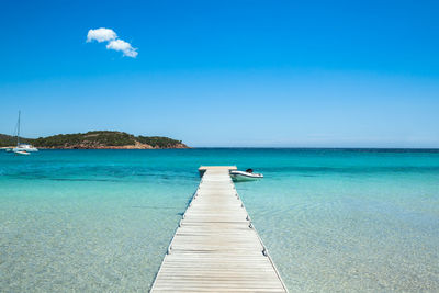 Pier over sea against blue sky