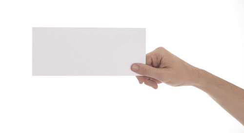 Midsection of person holding paper against white background