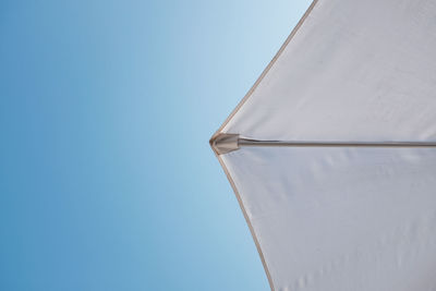 Low angle view of airplane against clear blue sky