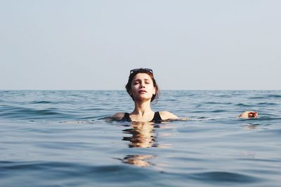 Portrait of young woman swimming in sea