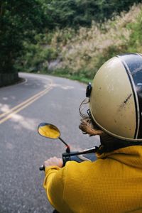 Close-up of yellow riding motorcycle on street