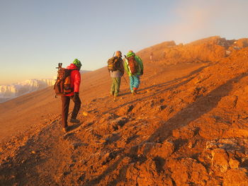 Men on landscape against sky