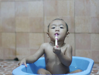 Portrait of shirtless boy in bathroom