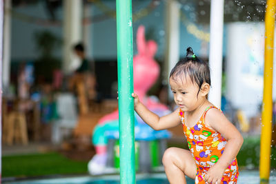 Close-up of cute girl standing at water park