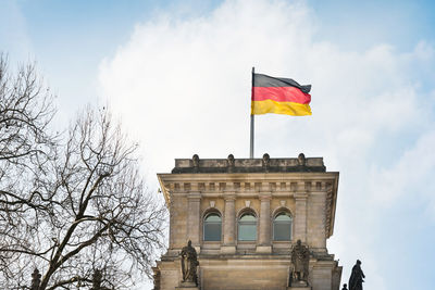 Low angle view of german flag on building against sky