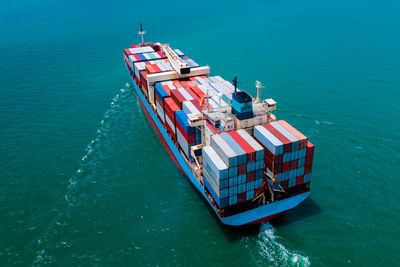 High angle view of shipping containers sailing on sea