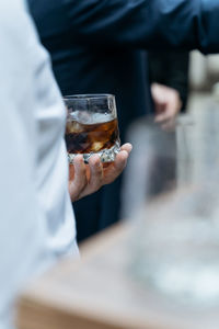 Man holding glass with whiskey on the party