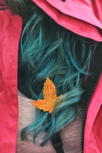 Close-up of woman with orange flower